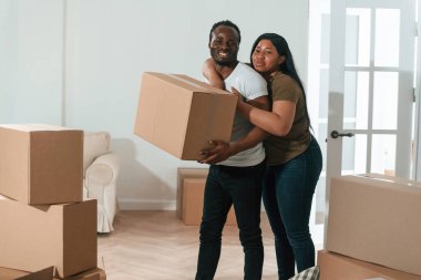 Kutuları tutuyorum. Afrikalı Amerikalı çift yeni eve taşınıyor..