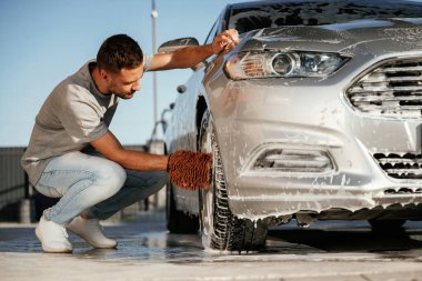 Oturup otomobili yıkıyorum. Adam dışarıda arabasıyla bekliyor..