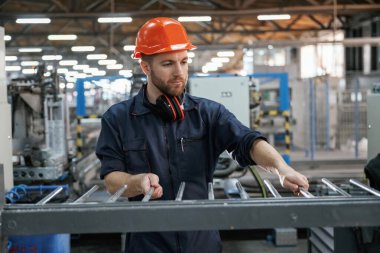 Endüstriyel hat çalışıyor. Fabrika işçisi kasketli bir şekilde içeride..