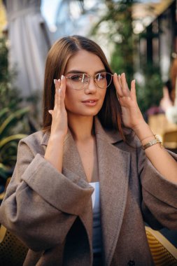 Gözlük takıyordu. Güzel genç bayan dışarıda..