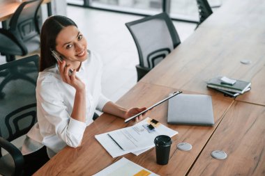 Telefonla konuşuyorum. İş kadını ofisin içinde..