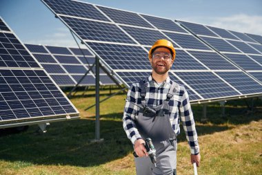 Çalışmaya hazır, matkapla. Gündüz vakti fotovoltaik güneş panelleri olan bir mühendis..