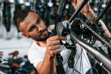 Tekerlek ve fren sistemini kontrol ediyorum. Bisiklet dükkanında tamirci, mağazada çalışıyor..