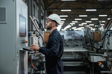 Ekipman kullanıyoruz, santral. Fabrika işçisi kasketli bir şekilde içeride..