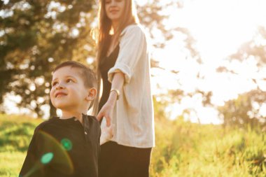 Birbirlerinin ellerini tutarak. Anne ve oğlu ormanda beraberler..