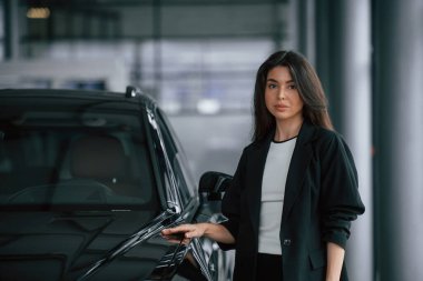 Araba galerisindeki kadın, otomobil satıyor..