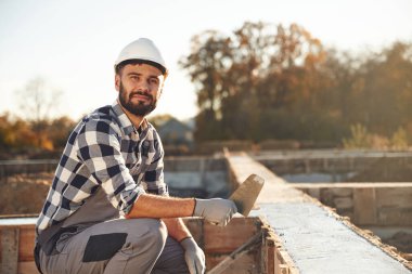 Evin temeline beton döşemek. İşçi gündüz vakti şantiyede..