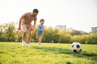 Futbol oynuyordum. Mutlu baba ve oğul yazın sahada eğleniyorlar..