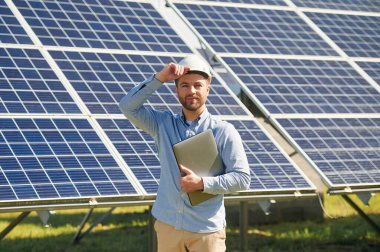 Dizüstü bilgisayarla. Gündüz vakti fotovoltaik güneş panelleri olan bir mühendis..
