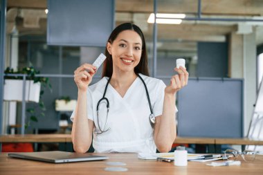 Profesyonel pratisyen. Beyaz önlüklü kadın doktor içeride..