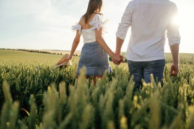 Arkadan bakın, el ele tutuşun, yürüyün. Güzel bir çift yeşil tarlada birlikte..