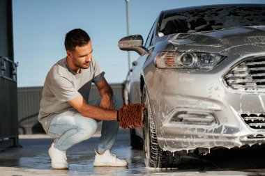 Oturup otomobili yıkıyorum. Adam dışarıda arabasıyla bekliyor..