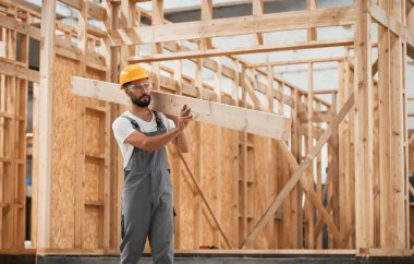 Yürüyorum, kalas tutuyorum. Ahşap depoda sanayi işçisi..