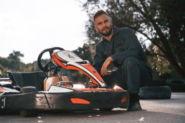 Teknisyen araca bakıyor. Erkekler açık havada, kart yarışı gebeliği..