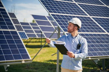 Gündüz vakti fotovoltaik güneş panelleri olan profesyonel yetişkin mühendis..