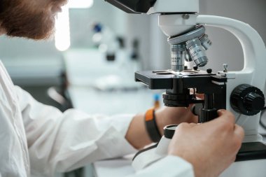Profesyonel laboratuvar çalışanı mikroskop kullanıyor..