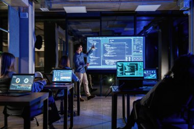 Erkek işletme eğitmeni projektöre karşı, insanlara öğretiyor..