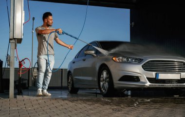 Araba yıkama servisi, adam dışarıda arabasıyla bekliyor..