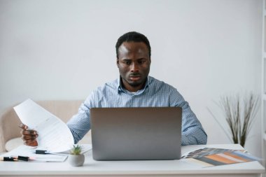 Ön manzara. İşadamı ofiste bilgisayarla çalışıyor..