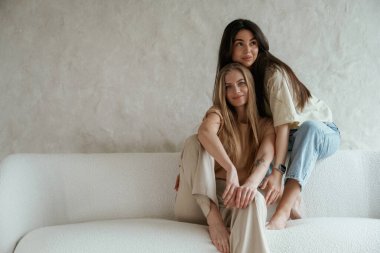 Beyaz duvara yaslan. İki mutlu genç bayan en iyi arkadaş içeride..