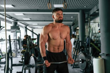 Güçlü kaslı adam spor salonunda çalışıyor..