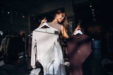 Güneş ışığıyla aydınlandı, karardı. Kadın mağazadan kıyafet seçiyor..