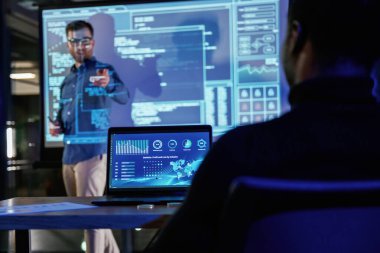 Projeden bahsediyorum. Erkek işletme eğitmeni projektöre karşı, insanlara öğretiyor..