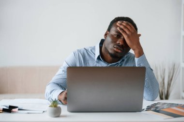 Kötü ve stresli hissediyorum. İşadamı ofiste bilgisayarla çalışıyor..