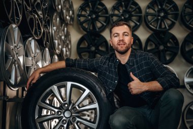 Başparmak yukarı, jest. Tekerlekleri ve tekerlekleri olan tamirci var..