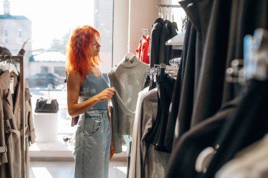 Basit ama güzel bir tasarım. Kadın mağazadan kıyafet seçiyor..