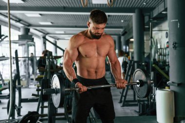 Güçlü kaslı adam spor salonunda çalışıyor..