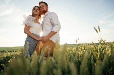 Yakınlık, birbirini kucaklamak. Güzel bir çift yeşil tarlada birlikte..