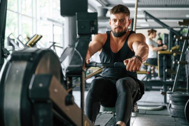Dayanıklılık egzersizi. Güçlü kaslı adam spor salonunda çalışıyor..