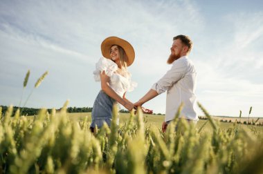 Birbirimizin elini tutuyoruz. Güzel bir çift yeşil tarlada birlikte..