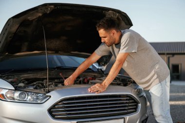 Bozuk otomobili tamir etmeye çalışıyorum. Adam dışarıda arabasıyla bekliyor..