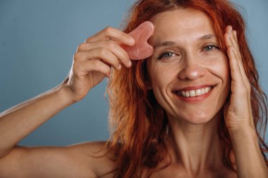 Yama kullanarak cildin yaşlanmasını önlüyor. Kadın stüdyoda arka planda..