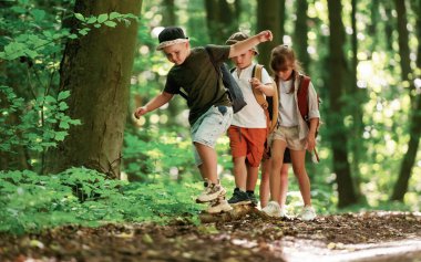 Patikaya doğru gidiyor. Çocuklar yazın gündüz vakti ormanda..