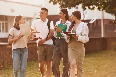 Güneş ışığıyla aydınlatılmış. Bir grup öğrenci birlikte dışarı çıktılar..