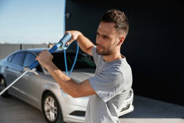 Otomobili yıkamaya hazırım. Adam dışarıda arabasıyla bekliyor..