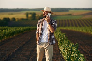 Telefonla konuşuyorum. Çiftçi tarım alanında..