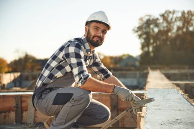 Evin temeline beton döşemek. İşçi gündüz vakti şantiyede..