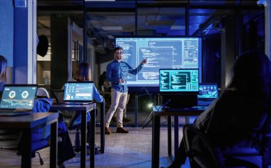 Projeden bahsediyorum. Erkek işletme eğitmeni projektöre karşı, insanlara öğretiyor..