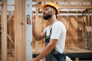 Seviye aleti. Ahşap depoda sanayi işçisi..