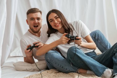 joysticklerle video oyunu oynuyorum. Genç çift evde birlikteler..