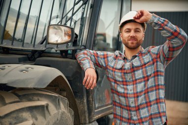 Araca yaslan. Adam traktörle birlikte. Tarım işçisi.