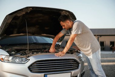 Bozuk otomobili tamir etmeye çalışıyorum. Adam dışarıda arabasıyla bekliyor..
