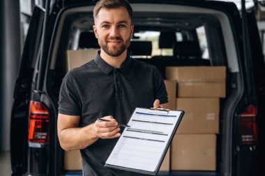 Not defterindeki siparişi doğrula. Teslimatçı ya da yükleyici arabanın yanında.