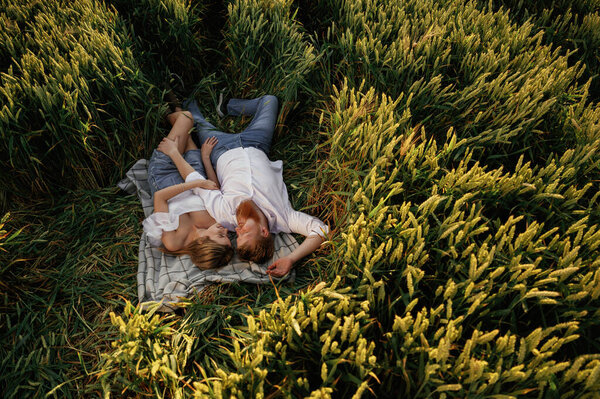 Отдыхаю, ложусь, вид сверху. Прекрасная пара на зеленом сельскохозяйственном поле вместе.