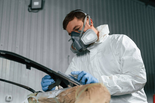 Металлическая туша. Ремонтник работает в гараже.