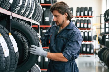 Eldivenli, lastikli profesyonel işçi. Lastik tamir servisinde adam var..